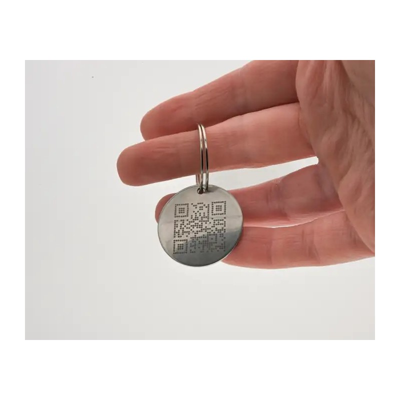 Placa redonda para mascota personalizada con grabado en metal sostenida en la mano