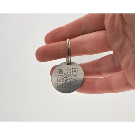 Placa redonda para mascota personalizada con grabado en metal sostenida en la mano