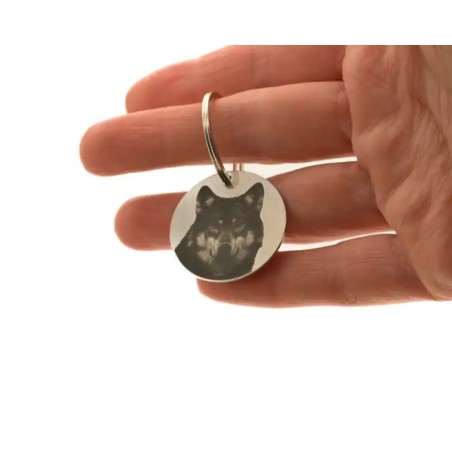 Placa redonda para perro sostenida en la mano con grabado personalizado