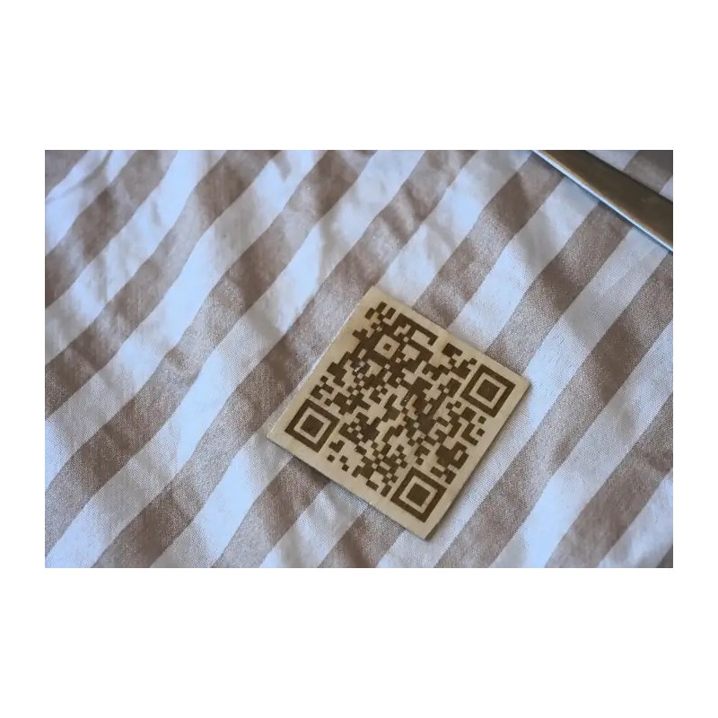 Codigo QR minimalista grabado en madera cuadrada.