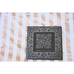 Posavasos corporativo premium en pizarra natural con marco ornamental y codigo QR.