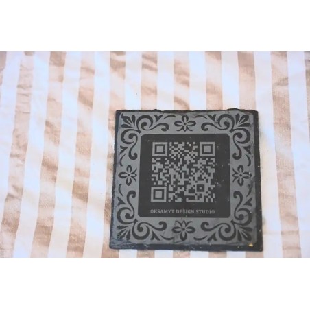 Posavasos corporativo premium en pizarra natural con marco ornamental y codigo QR.