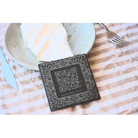 Posavasos corporativo premium en pizarra natural con marco ornamental y codigo QR.