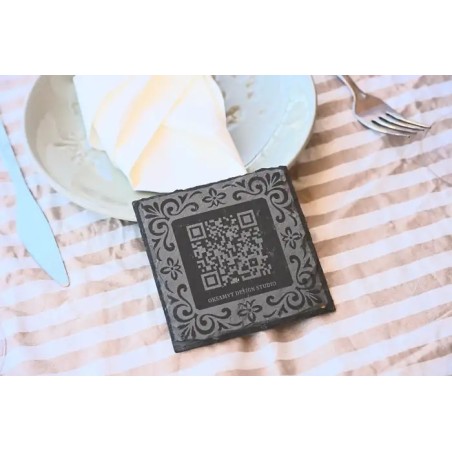Posavasos corporativo premium en pizarra natural con marco ornamental y codigo QR.