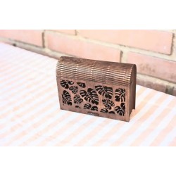 Caja de madera con patron de hojas monstera caladas.