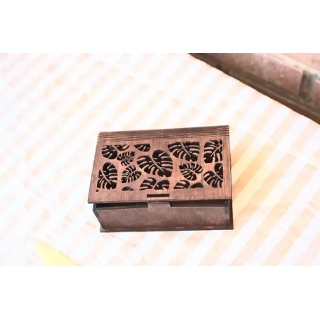 Caja de madera con patron de hojas monstera caladas.